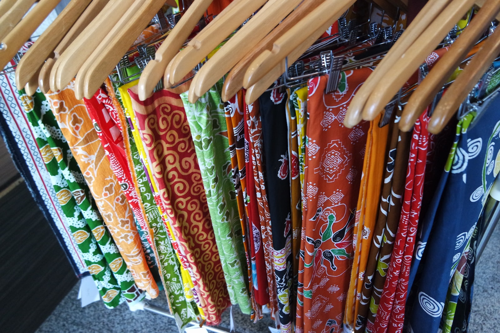 a rack of cloths and wooden clothes hangers