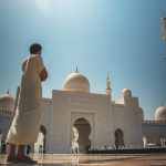 man standing near white mosque
